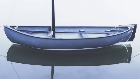 Offenes blaues Boot mit Segelmast